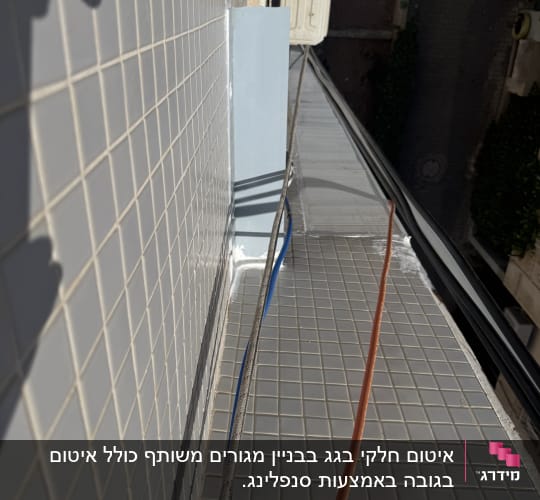 עבודת איטום על גג עם אריחים וכבלים חשמליים